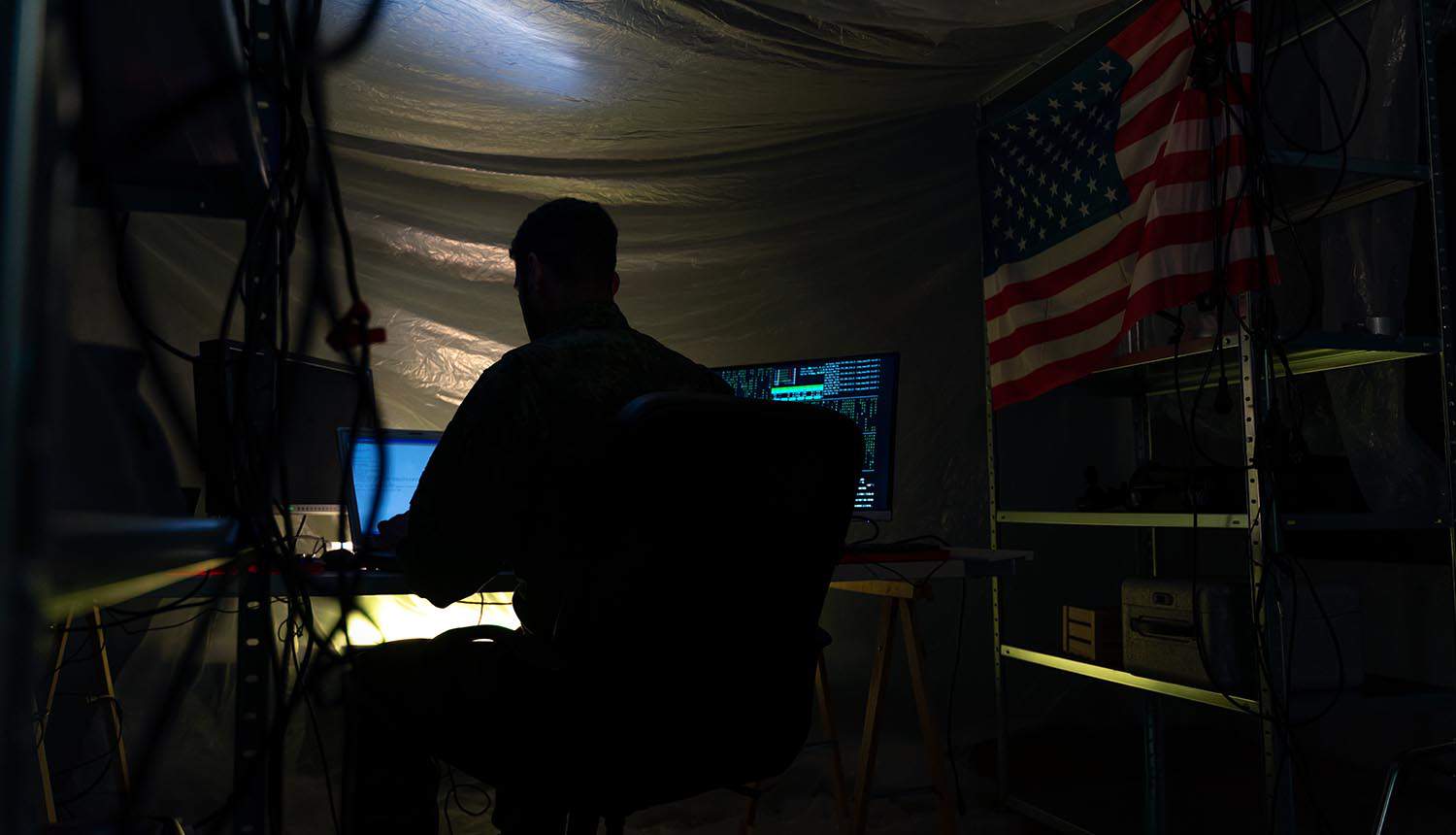 U.S. hacker in military uniform showing cyber espionage on China research university