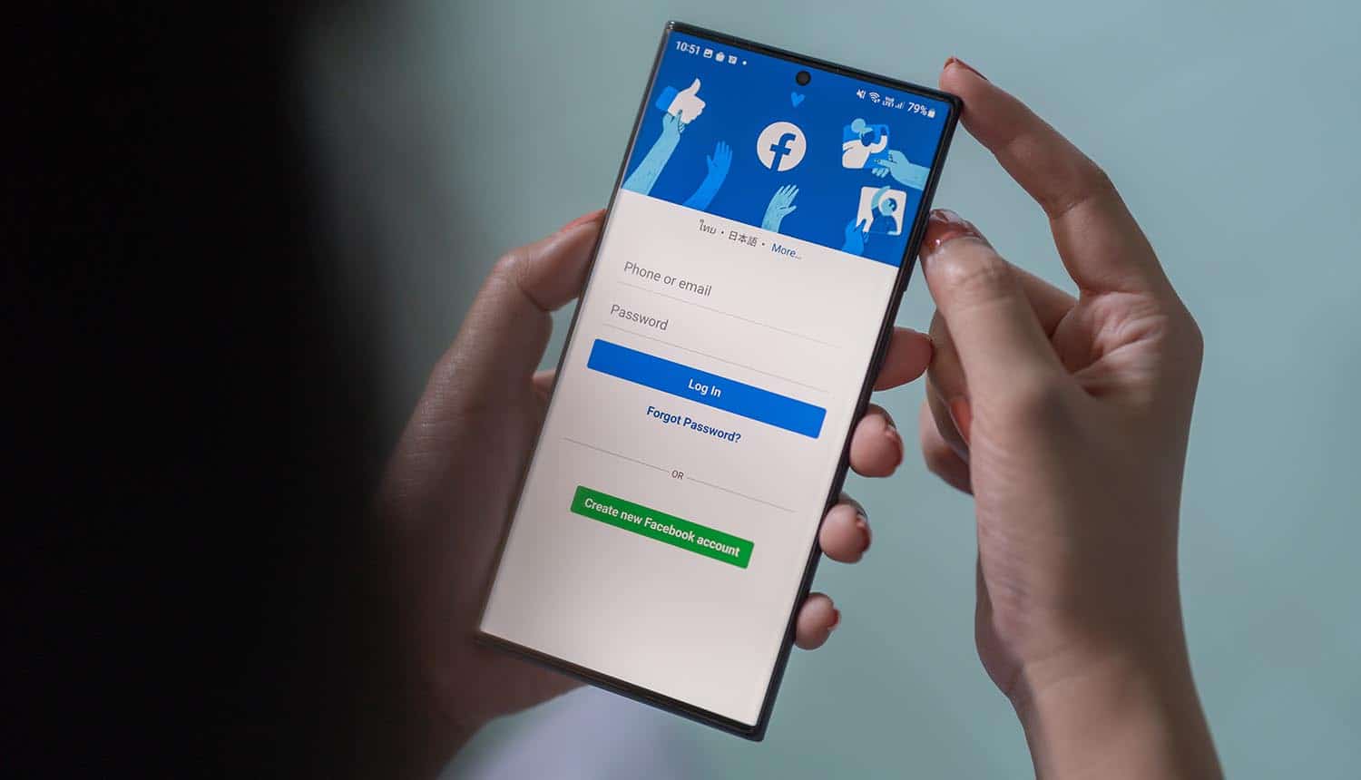 Phone in the hand with Facebook app showing malicious apps targeting login information