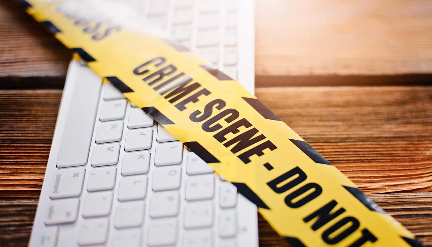 Yellow crime scene tape on computer keyboard showing law enforcement operation on Hive ransomware