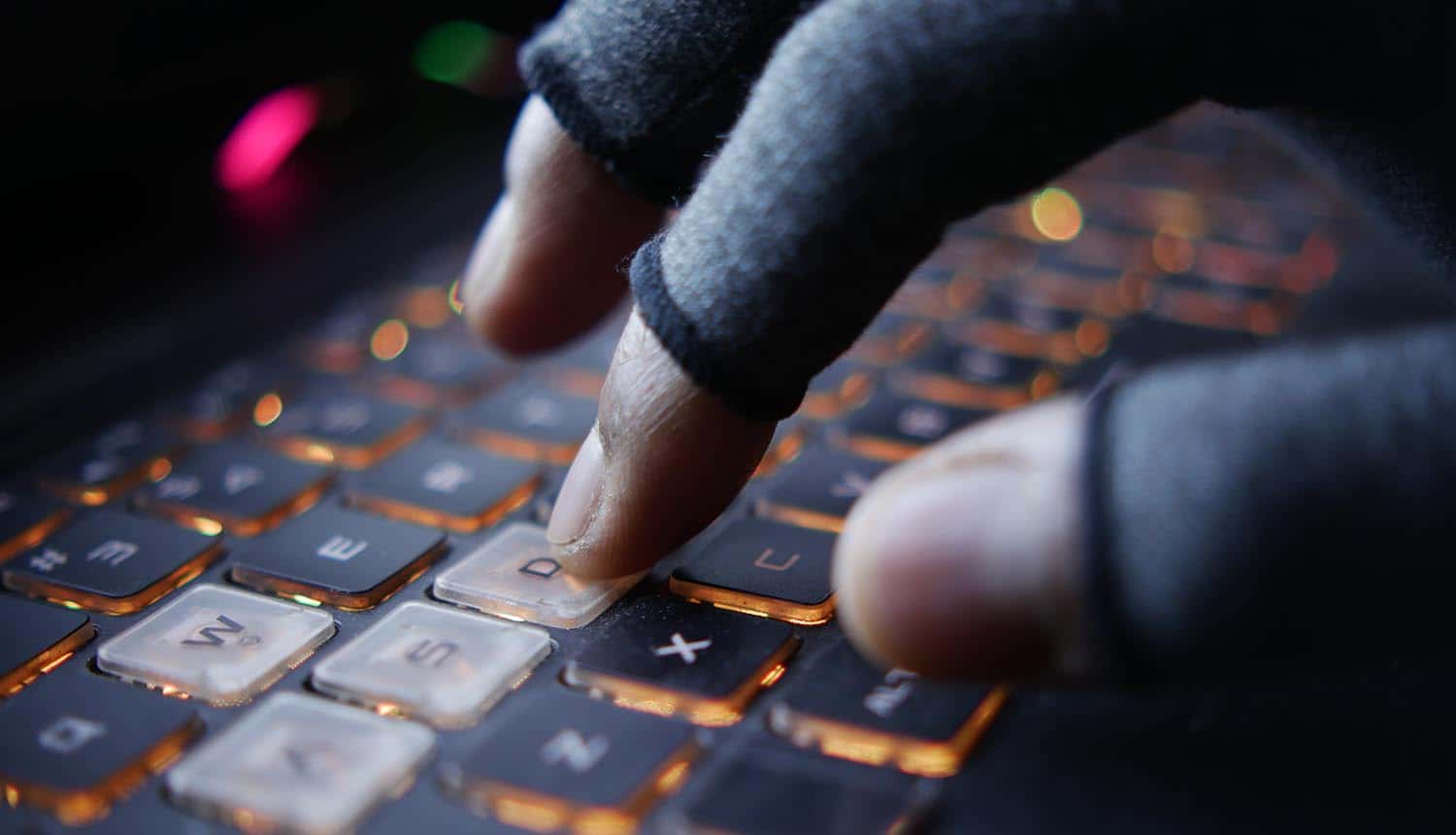 Hacker hand stealing data from laptop showing data breach at hardware supplier TSMC