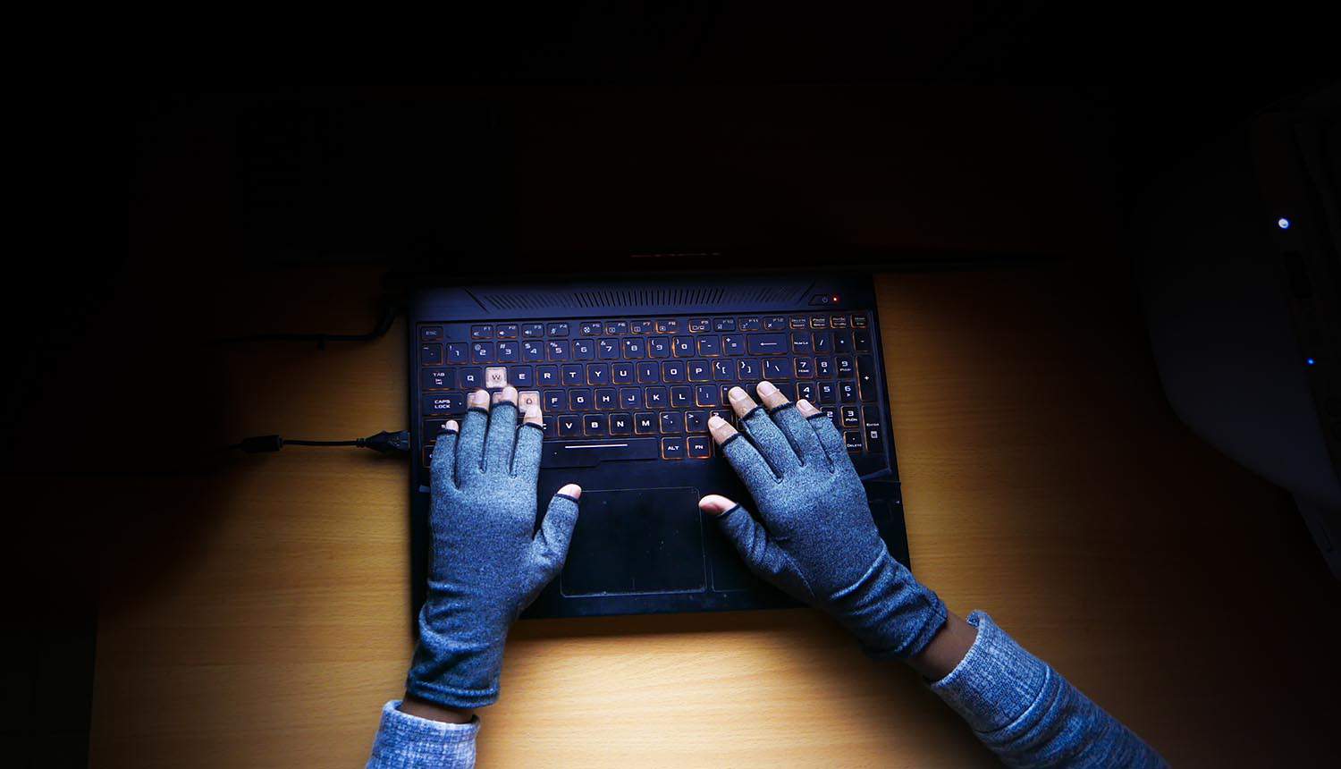 Hacker hand stealing data from laptop showing MOVEit data breach exposed health data from government contractor