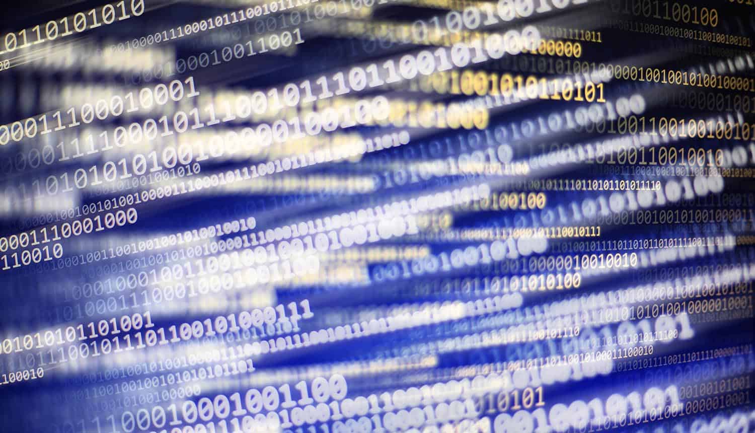Binary code on monitor screen showing software supply chain attacks
