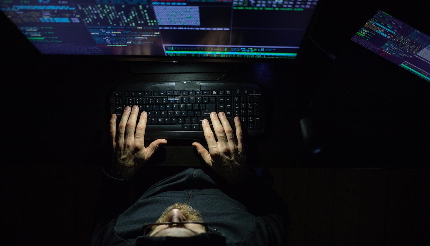 Hacker working at night showing nuclear site infiltrated by hacker groups