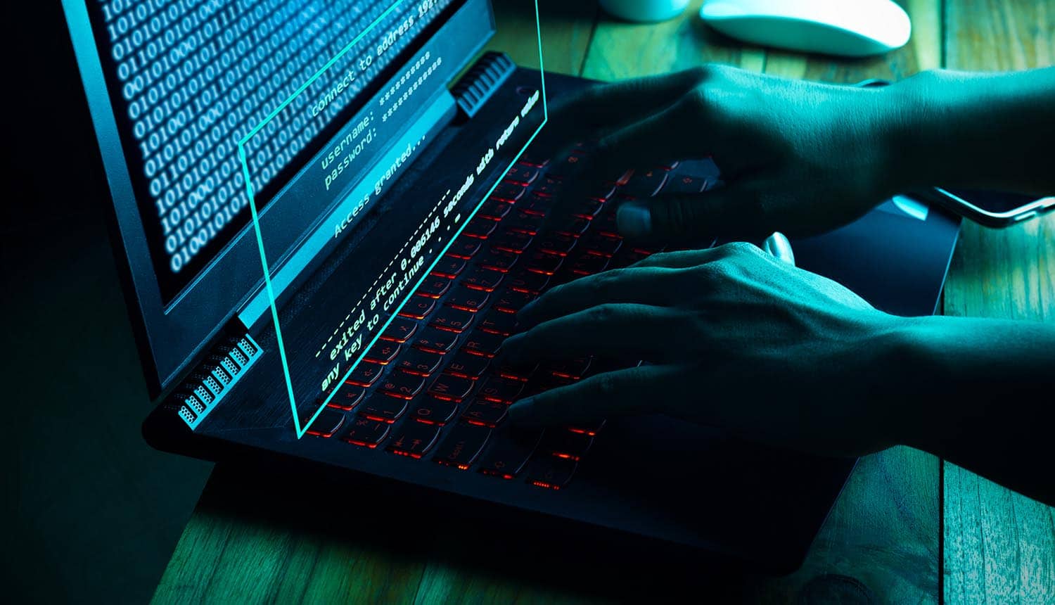 Hacker working on laptop showing data leaks and password