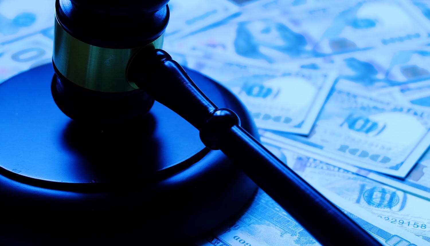 Wooden gavel on dollar notes showing cyber attack impact on art auctions