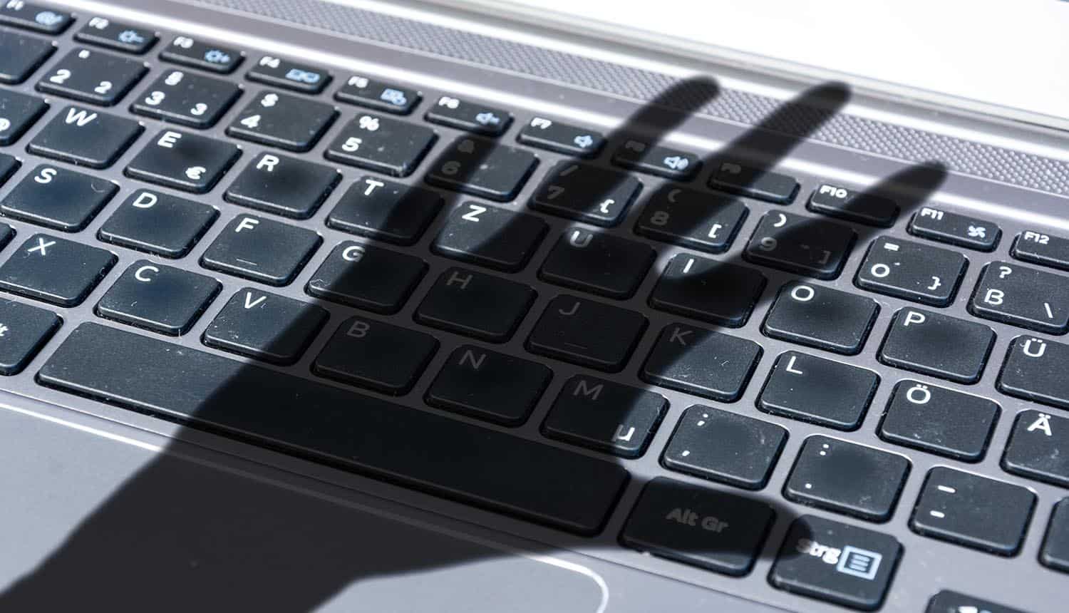 Dark shadow of a hand reaches for keyboard showing Europol data breach exposing classified information
