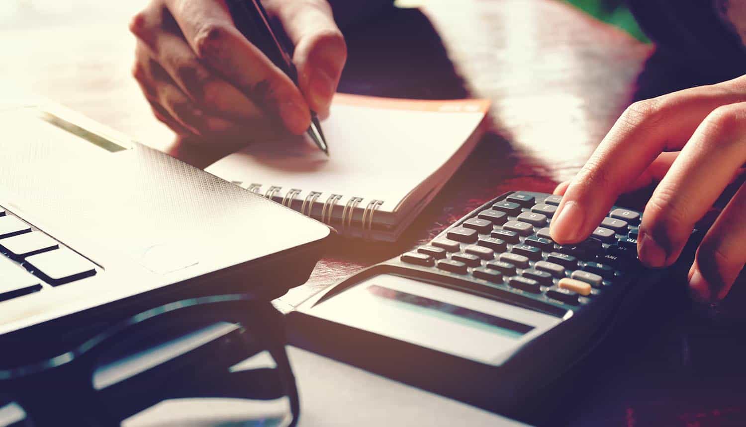 Hand using calculator showing cost of data breach