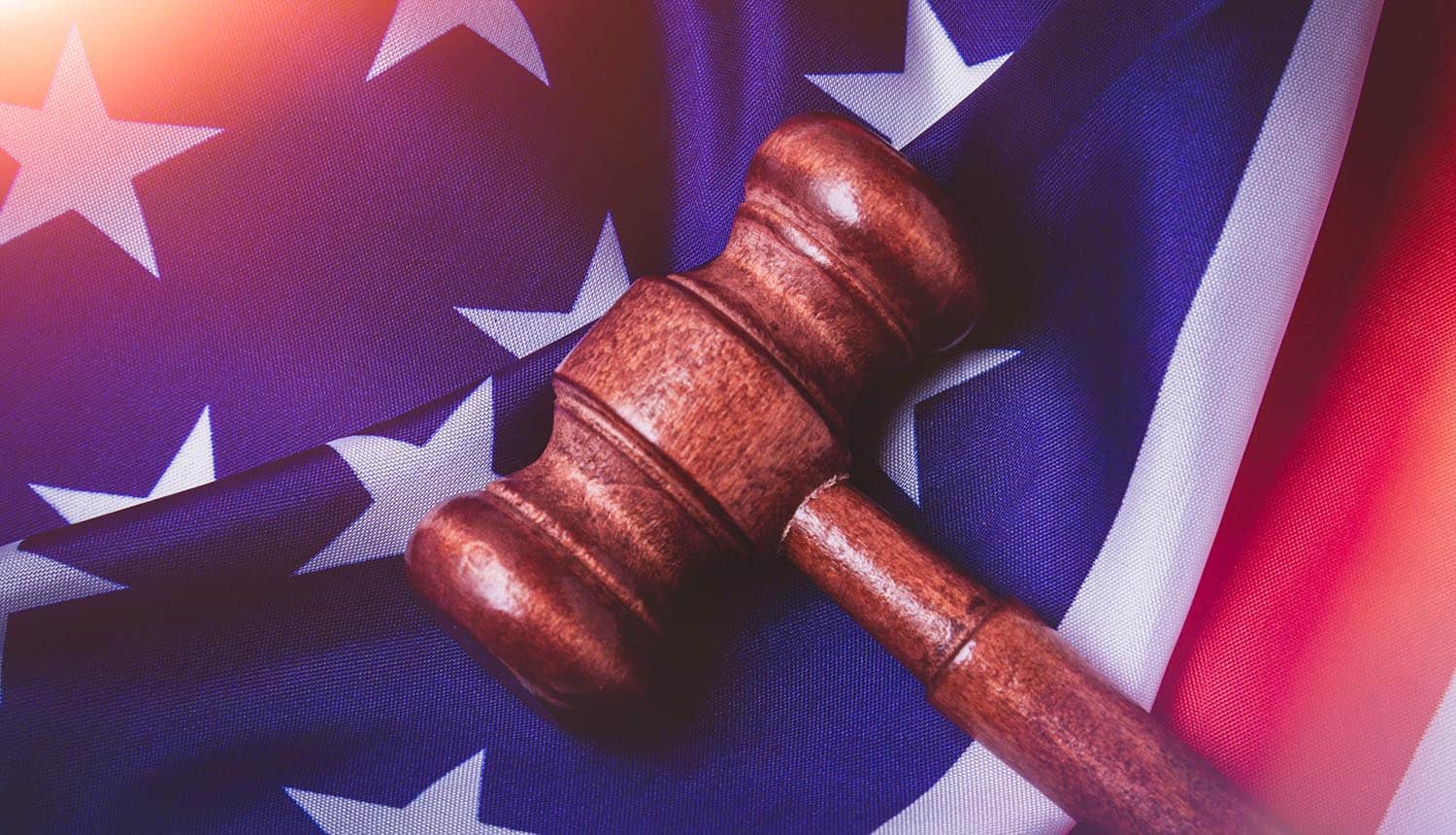Hammer on US flag showing cybersecurity law for information sharing