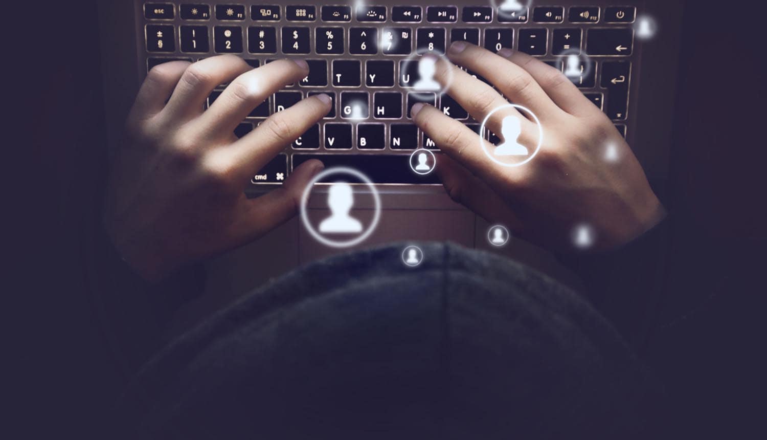 Hands typing on laptop showing data leak of user profiles