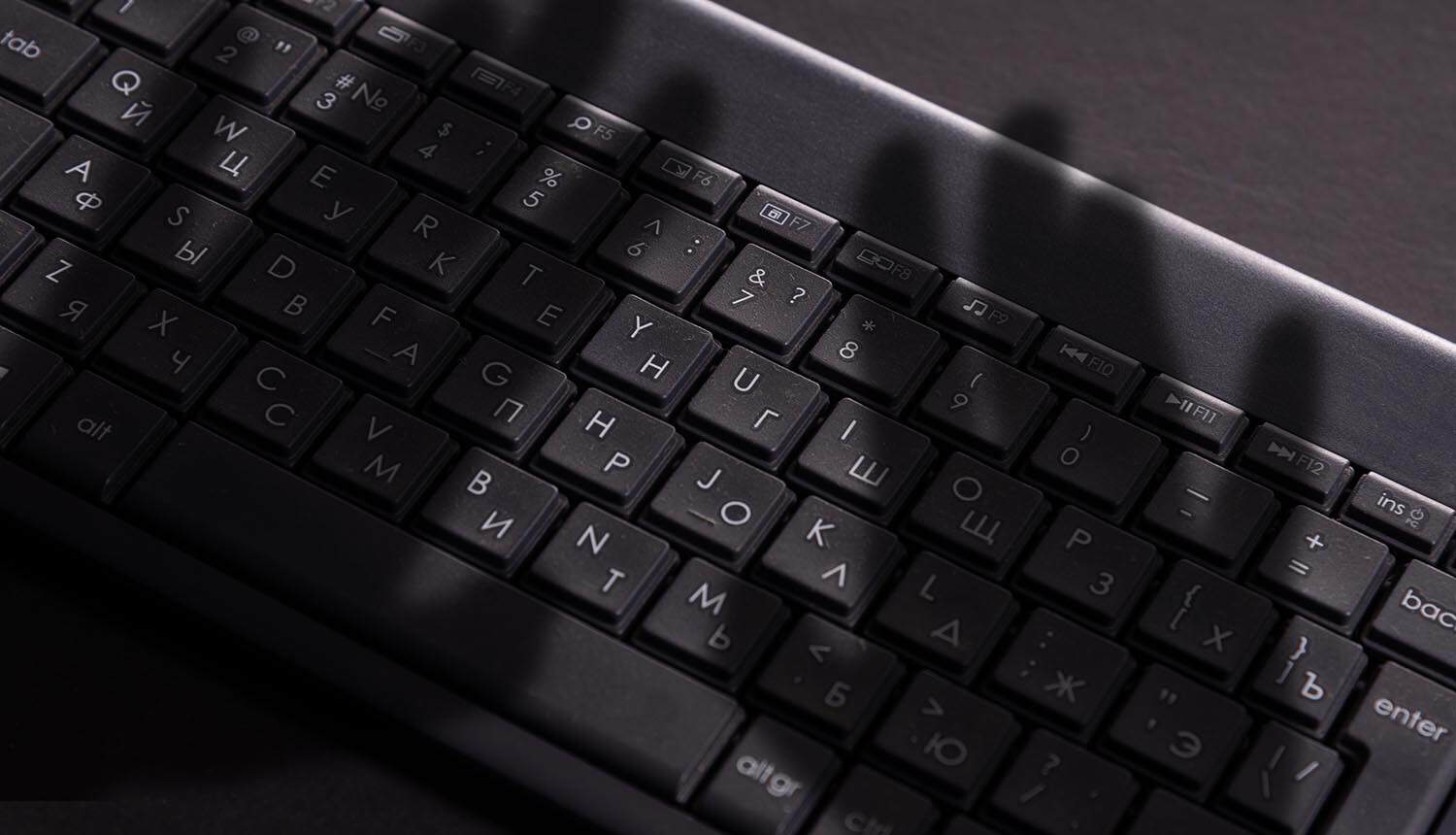 Dark shadow of hand on keyboard showing data theft with Copilot vulnerability