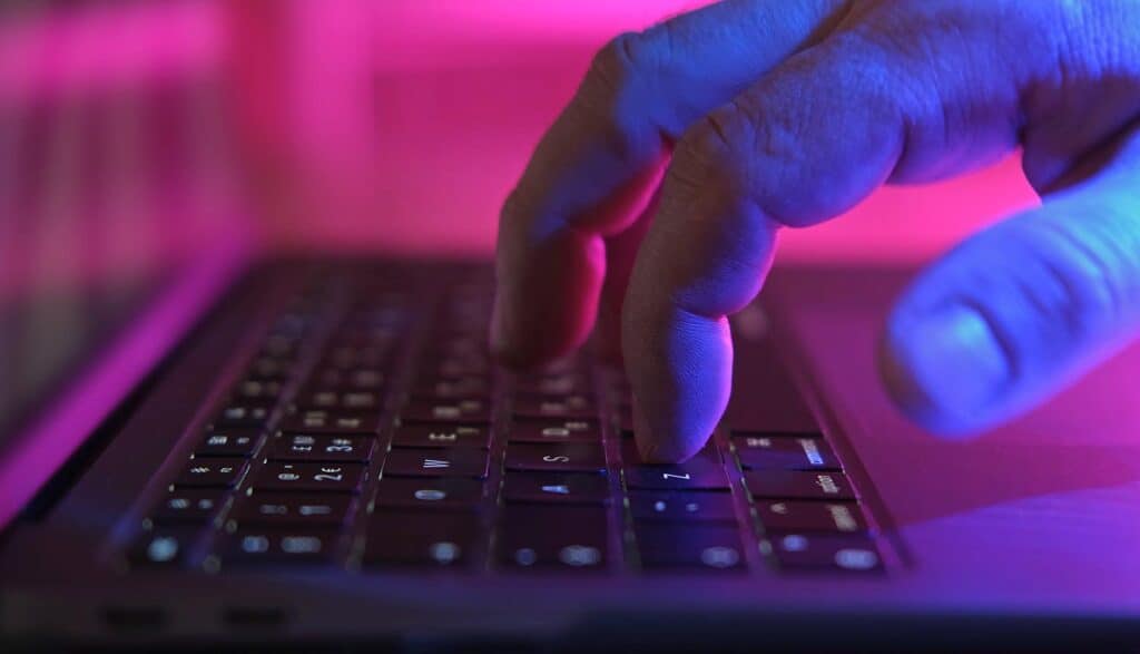 Hands on laptop showing AI workflows identity hijacking