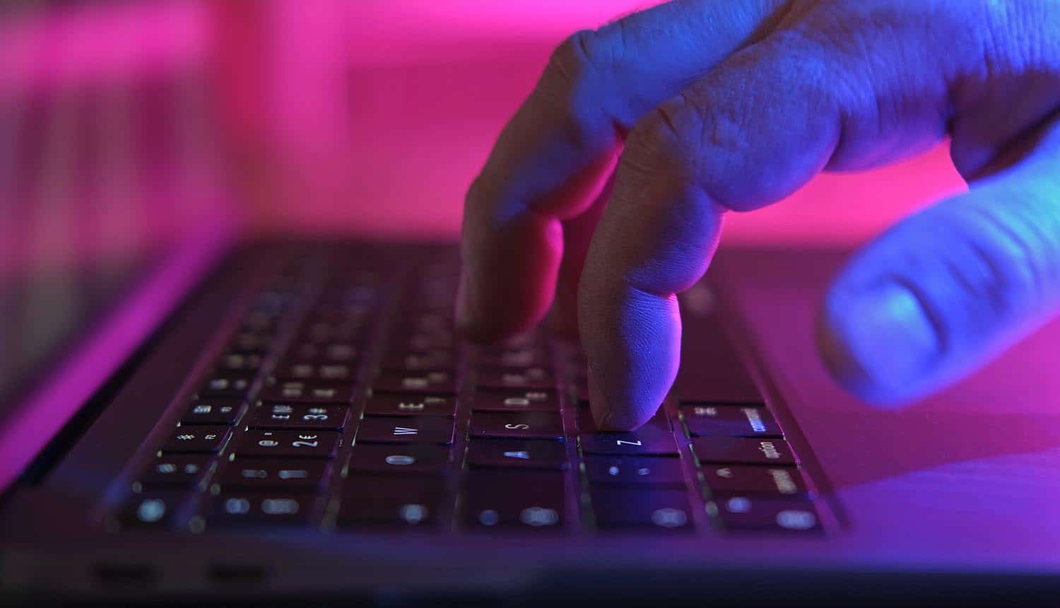 Hands on laptop showing AI workflows identity hijacking