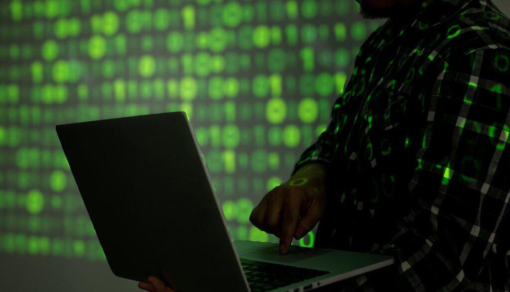 Hacker with laptop showing AI agents