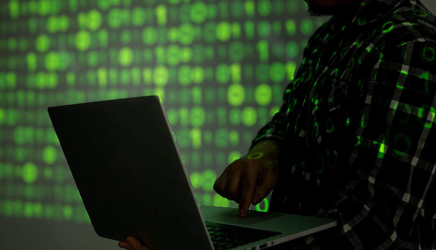 Hacker with laptop showing AI agents